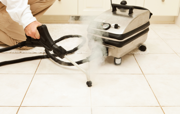Person using a steam cleaner to clean the toilet floor